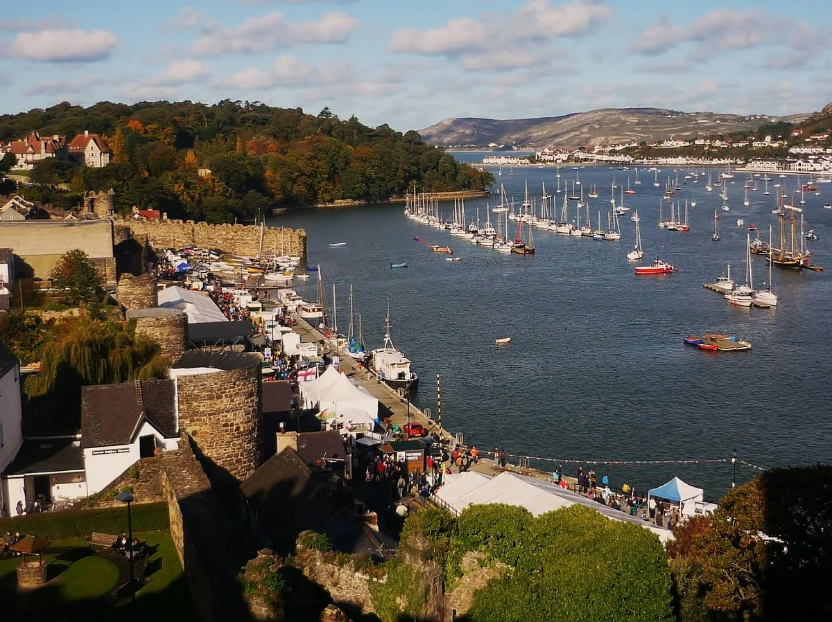 Conwy Quay with boats and castle backdrop.